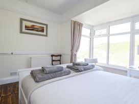 A bedroom with a bed and towels arranged at Sea Ledge in Tintagel