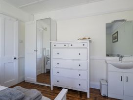 A bedroom with a chest of drawers and a mirror at Sea Ledge in Tintagel