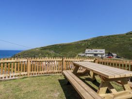 An outdoor area with a wooden table and fence at Sea Ledge in Tintagel