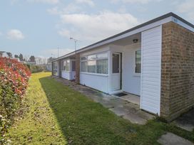 A row of single-story homes with grass and hedges outside at Chalet 469 in Newport Norfolk