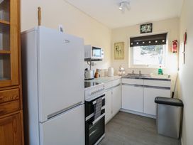 A kitchen with a white refrigerator stove microwave and sink at Chalet 469 Newport Norfolk