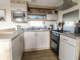 A kitchen with a microwave toaster kettle stove sink and utensils at Breathing Space Happisburgh near Walcott