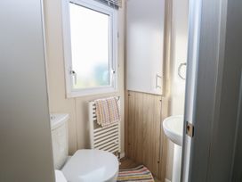A small bathroom with a toilet sink towel radiator and window at Breathing Space Happisburgh near Walcott