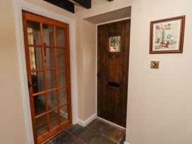 A hallway with a wooden door and a glass-paneled door with a framed picture on the wall at Timberwick Green Akeld near Wooler