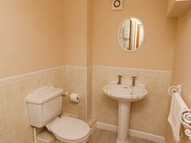 A bathroom with a toilet a pedestal sink a mirror and a towel rack at Timberwick Green Akeld near Wooler