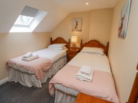 A bedroom with two single beds bedside table lamp and animal paintings at Timberwick Green in Akeld near Wooler