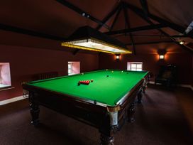 A games room with a snooker table and armchair at Timberwick Green Akeld near Wooler