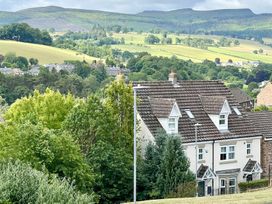 A house with trees and hills in the background at Harefield in Rothbury
