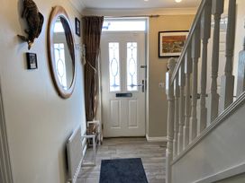 A hallway with a door and mirror at Harefield in Rothbury