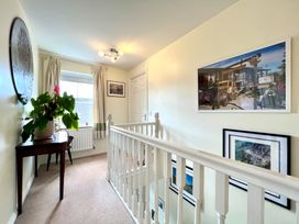 A hallway with a plant on a table and photographs on the wall at Harefield in Rothbury