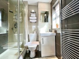 A bathroom with a shower, toilet, sink, and towels at Harefield in Rothbury