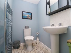 A bathroom with a toilet, sink, and towel rail at The Stable in Rosudgeon