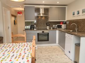 A kitchen with appliances and a dining table at Sea View Loft in Rosudgeon