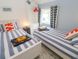 A bedroom with two beds and a wardrobe at Sea View Loft in Rosudgeon