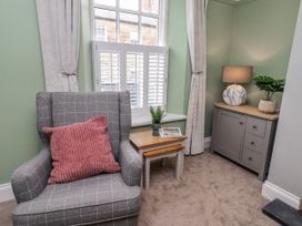 A sitting room with an armchair and a side table at 3 Lisburn Street Alnwick