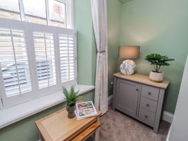 A corner with a cabinet, lamp, plant, and magazine at 3 Lisburn Street Alnwick