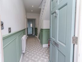 A hallway with a door and stairs at 3 Lisburn Street Alnwick