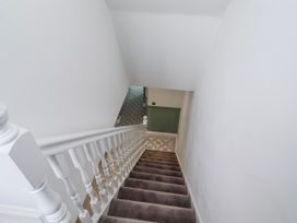 A staircase with a handrail leading to a door at 3 Lisburn Street Alnwick