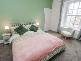 A bedroom with a bed and nightstands at 3 Lisburn Street Alnwick
