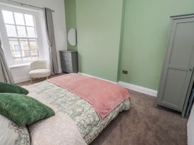 A bedroom with a bed and a chair at 3 Lisburn Street Alnwick