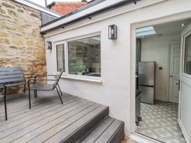 An outdoor seating area with chairs and a door leading to a kitchen at 3 Lisburn Street Alnwick
