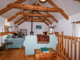 A living room with sofa and wooden beams at Coombe Barn in Cusgarne near St Day