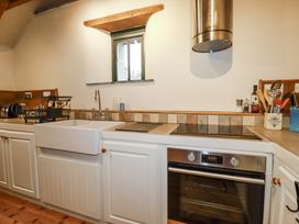 A kitchen with a sink and stove at Coombe Barn Cusgarne near St Day
