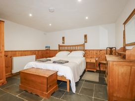 A bedroom with a bed and wooden furniture at Coombe Barn in Cusgarne near St Day
