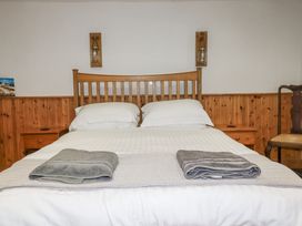 A bedroom with a wooden bed and towels at Coombe Barn Cusgarne near St Day