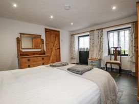 A bedroom with a bed, dresser, and chair at Coombe Barn Cusgarne near St Day