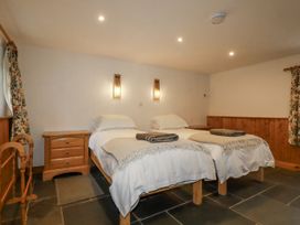 A bedroom with two beds and bedside tables at Coombe Barn Cusgarne near St Day