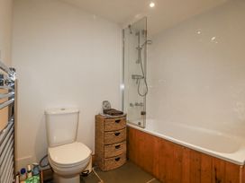 A bathroom with a toilet and a bathtub at Coombe Barn in Cusgarne near St Day
