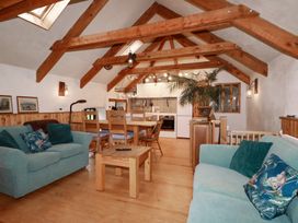 A living room with a sofa and dining table at Stribleys Barn in Cusgarne near St Day