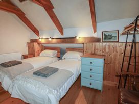 A bedroom with twin beds and wooden furniture at Stribleys Barn in Cusgarne near St Day