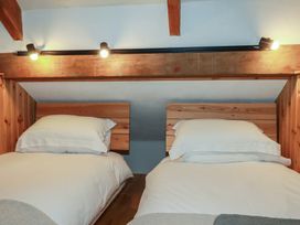 A bedroom with two single beds and wooden headboards at Stribleys Barn Cusgarne near St Day