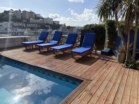 An outdoor space with sun loungers and a pool at Delmonte Lodge in Torquay