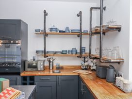A kitchen with shelving and various crockery at Delmonte Lodge in Torquay