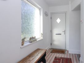 A hallway with a bench and a decorative window at Delmonte Lodge in Torquay