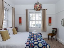 A bedroom with a bed and chair at Delmonte Lodge in Torquay