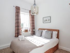 A bedroom with a bed and curtains at Delmonte Lodge in Torquay