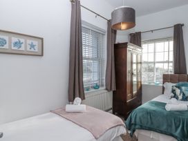 A bedroom with two beds and a wardrobe at Delmonte Lodge in Torquay