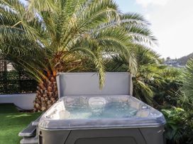 A hot tub surrounded by palm trees at Delmonte Lodge in Torquay