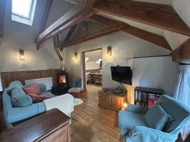 A living room with a sofa and television at Pit Paddy Barn in Cusgarne near St Day