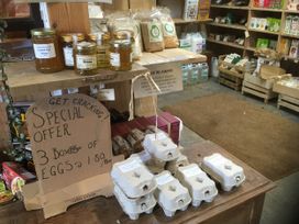 A store display with honey jars, egg boxes, and cereal bags at Pit Paddy Barn Cusgarne near St Day