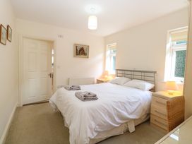 A bedroom with a double bed two bedside tables with lamps and framed pictures on the walls at Swallow Barn Holton near Halesworth