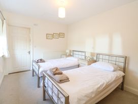 A bedroom with two single beds with white bedding and towels on each bed at Swallow Barn in Holton near Halesworth