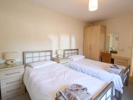 A bedroom with two single beds bedside tables lamps a wardrobe and a dressing table with chair at Swallow Barn Holton near Halesworth