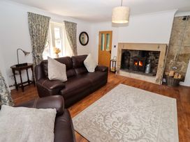 A living room with a fireplace and sofa at The Lodge Powburn
