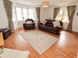 A living room with seating and a rug at The Lodge in Powburn