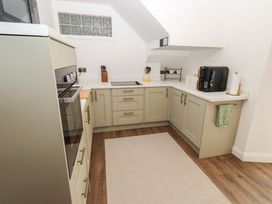 A kitchen with cabinets, stove, sink and countertop at The Lodge in Powburn